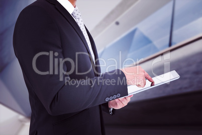 Composite image of businessman using his tablet pc Composite image of businessman using his tablet pc