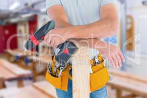 Composite image of midsection of male carpenter with power drill