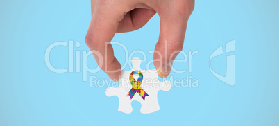 Composite image of hand holding jigsaw piece