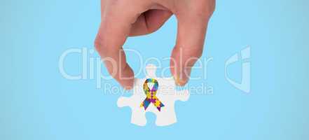 Composite image of hand holding jigsaw piece