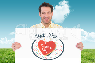 Composite image of attractive man smiling and holding poster