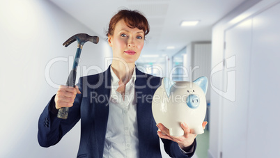 Composite image of businesswoman breaking piggy bank