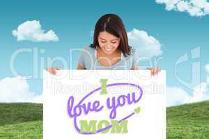 Composite image of good looking woman holding a  board