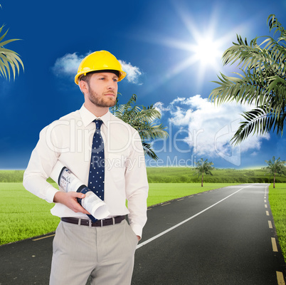 Composite image of young architect posing with hard hat and plan