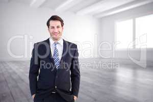 Composite image of smiling businessman standing with hands in po