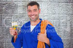 Composite image of smiling electrician with rolled wire and mult