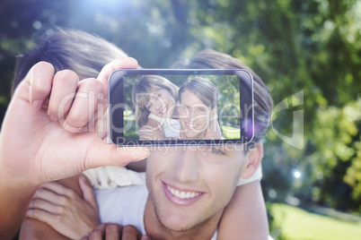 Composite image of hand holding smartphone showing Composite image of hand holding smartphone showing