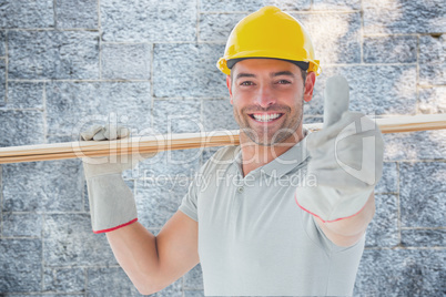 Composite image of worker with plank of wood