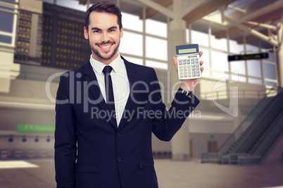 Composite image of smiling businessman presenting a calculator