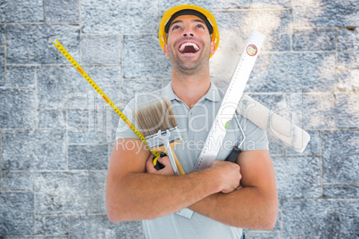 Composite image of laughing manual worker holding various tools