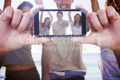 Composite image of hand holding smartphone showing