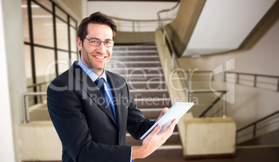 Composite image of businessman looking at the camera while using