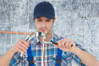 Composite image of plumber fixing pipe over white background