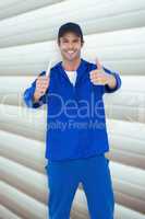 Composite image of happy mechanic holding spanner