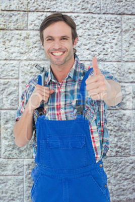 Composite image of confident plumber holding tool while gesturin