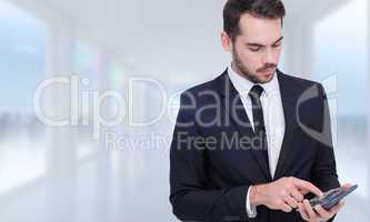 Composite image of concentrated businessman in suit using calcul