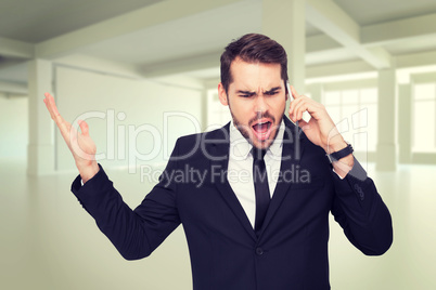 Composite image of angry businessman gesturing on the phone