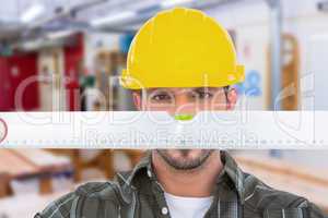 Composite image of handyman looking at spirit level