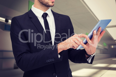 Composite image of mid section of a businessman using digital ta