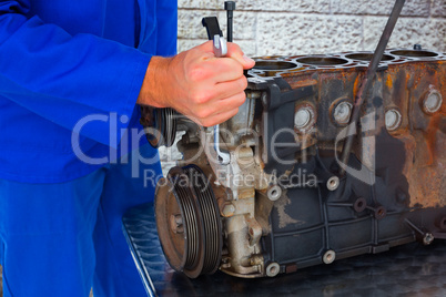 Composite image of male mechanic repairing car engine