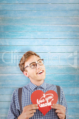 Composite image of geeky hipster holding a heart card