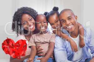 Composite image of happy family posing on the couch together