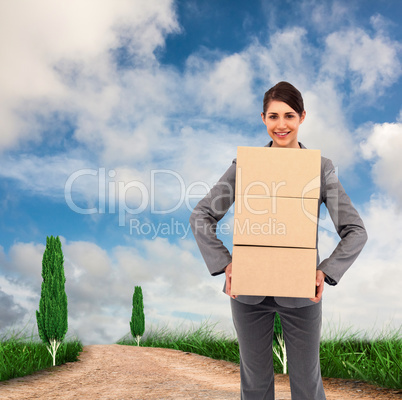 Composite image of smiling businesswoman carrying cardboard boxe