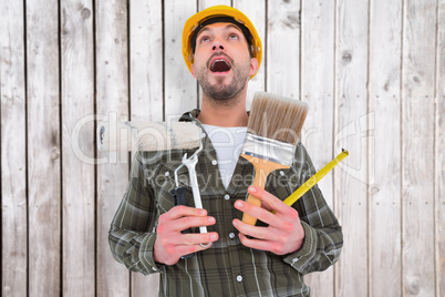 Composite image of screaming manual worker holding various tools