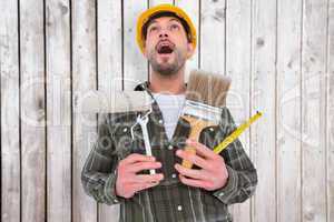 Composite image of screaming manual worker holding various tools