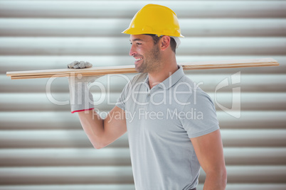 Composite image of worker with plank of wood