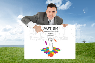 Composite image of businessman pointing at sign under him