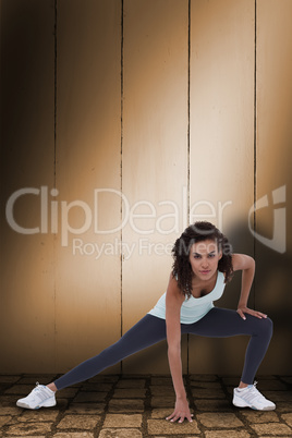 Composite image of fit woman stretching her legs