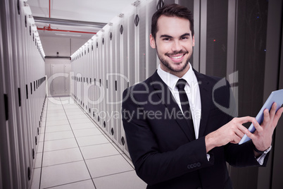 Composite image of businessman using his tablet while looking at