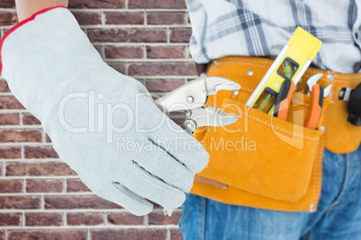 Composite image of technician using pliers over white background