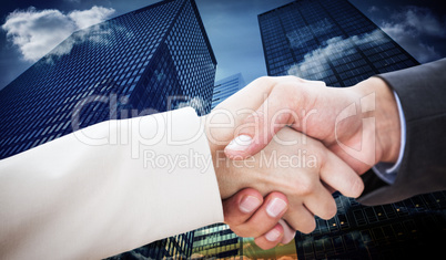 Composite image of close up on partners shaking hands