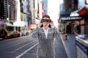 Composite image of surprised businesswoman looking through binoc