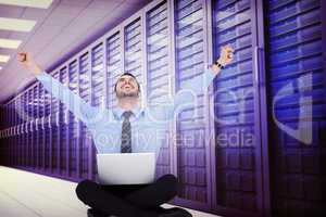 Composite image of businessman sitting on the floor cheering