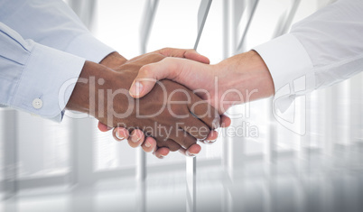 Composite image of close-up shot of a handshake in office