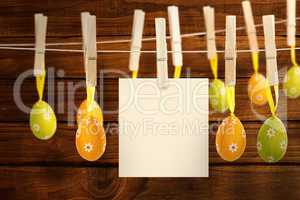 Composite image of hanging easter eggs and card