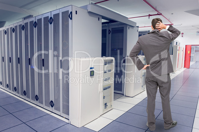 Composite image of young businessman standing back to camera scr