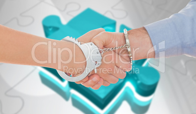 Composite image of handcuffed business people shaking hands