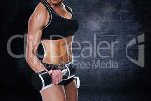 Composite image of female bodybuilder working out with large dum