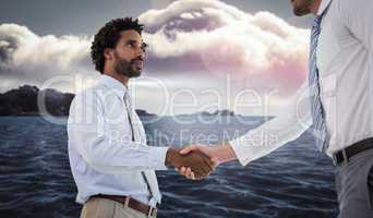 Composite image of young businessmen shaking hands in office