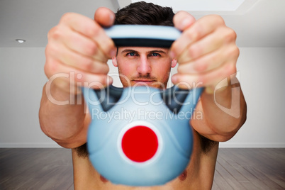 Composite image of bodybuilder holding kettlebell