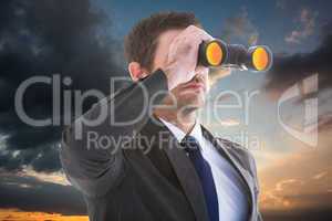 Composite image of young businessman looking through binoculars