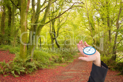 Composite image of businessman holding hand out in presentation