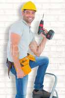 Composite image of confident handyman holding power drill while