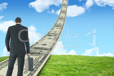 Composite image of rear view of businessman holding a briefcase