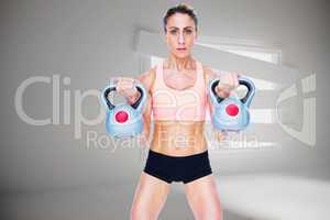Composite image of serious female crossfitter lifting kettlebell