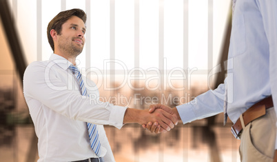 Composite image of young businessmen shaking hands in office